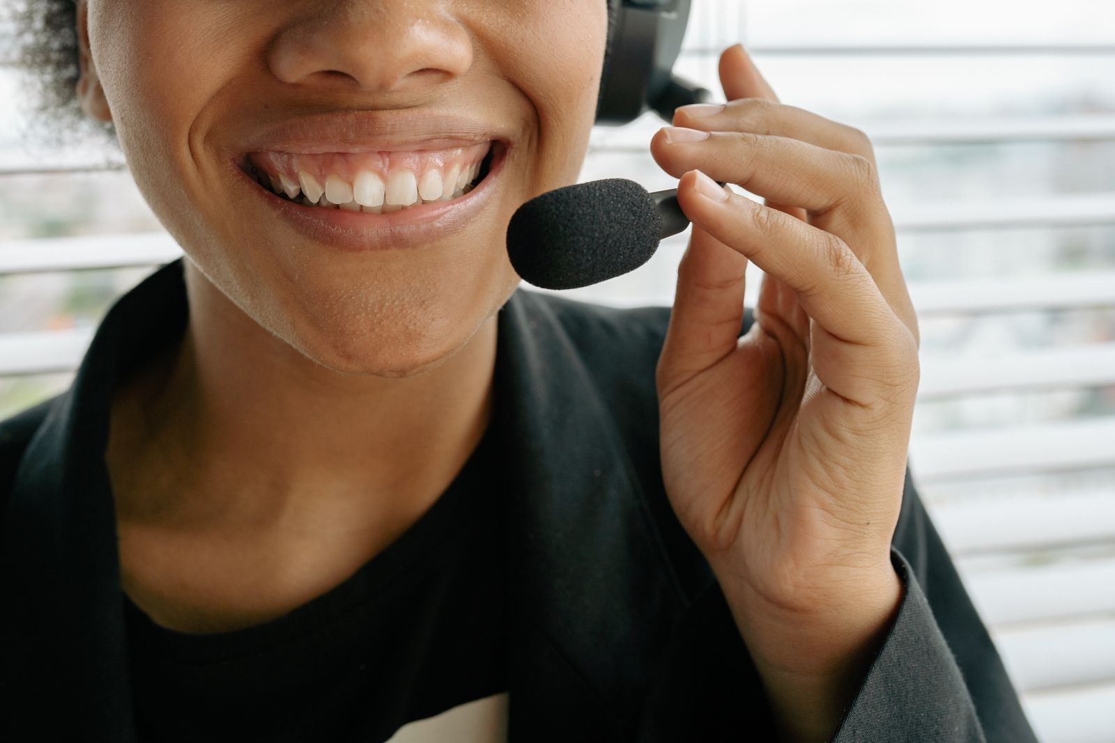 Close-up of a smiling call answering agent speaking into a headset microphone