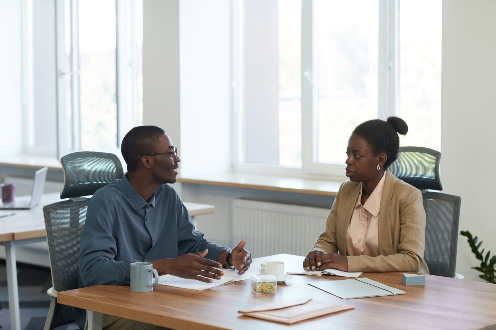 Two colleagues in conversation in a bright modern office
