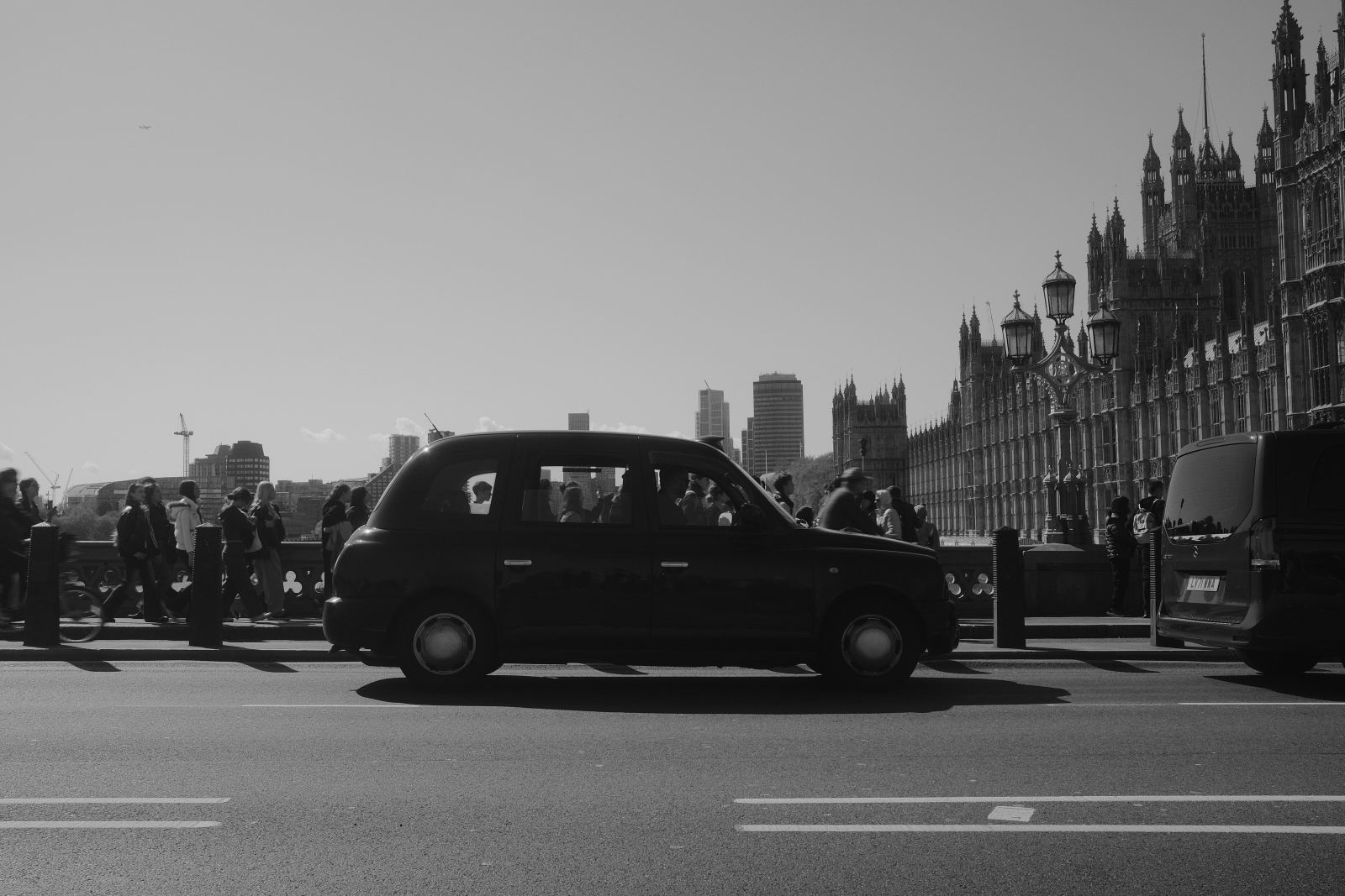 Black-and-white photo of a London taxi with the Houses of Parliament in the background