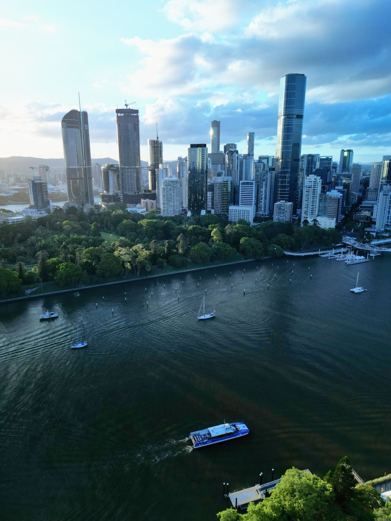 Aerial view of the Brisbane River, skyscrapers, and a passing ferry