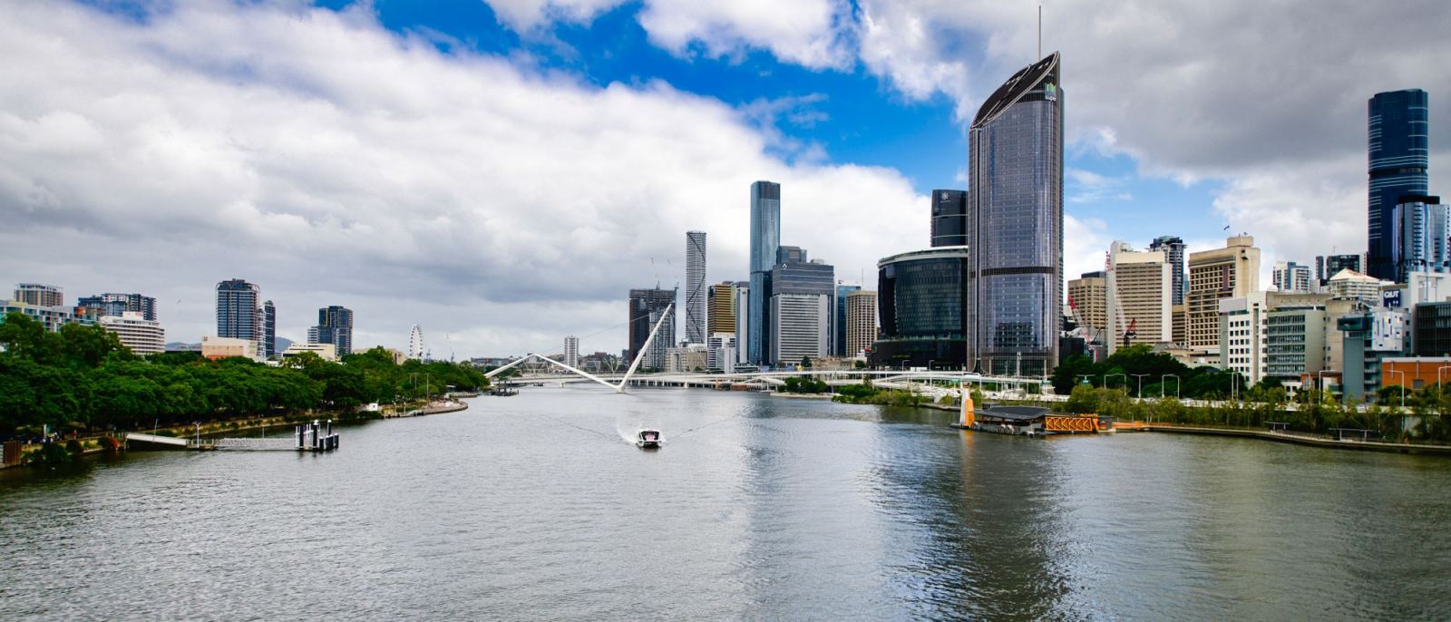 Panoramic view of the Brisbane River and skyline under a cloudy sky