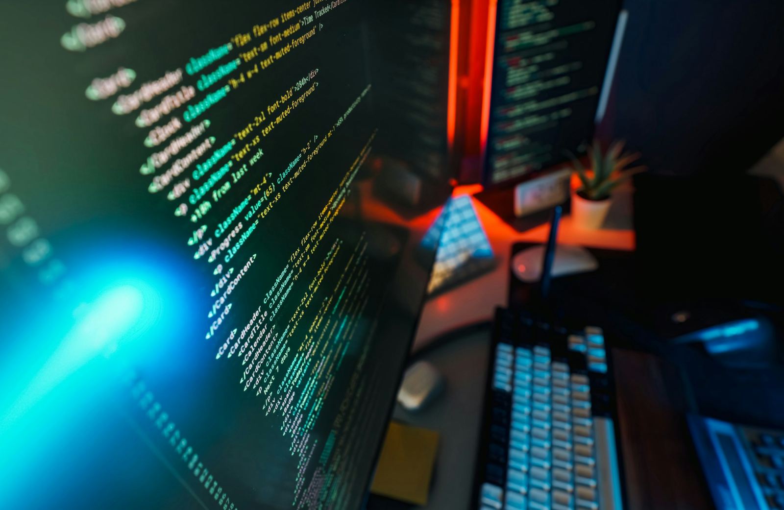 Close-up of code on a computer monitor with blue and red ambient lighting