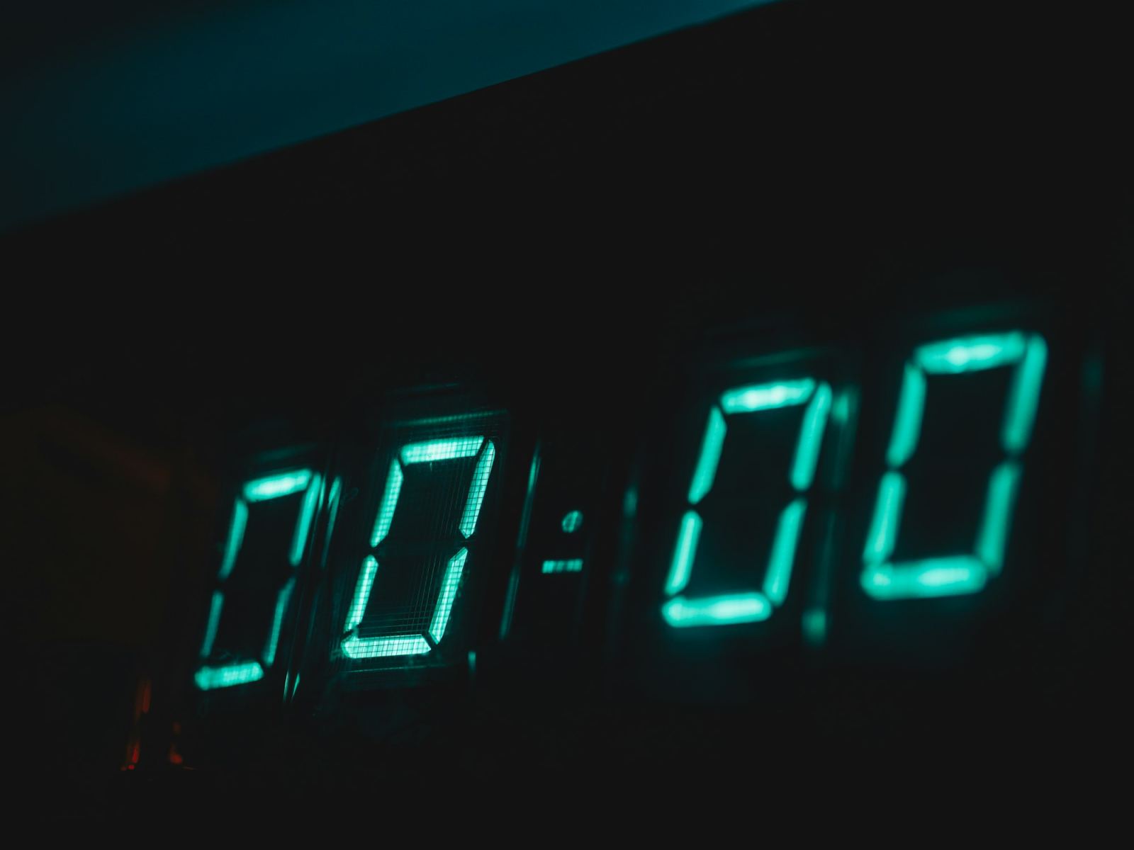 Digital clock display glowing teal showing 00:00 in a dark room