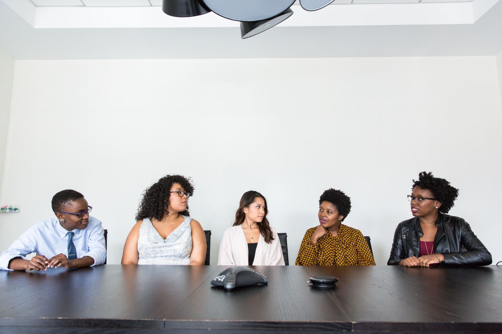 Five colleagues in discussion around a conference table