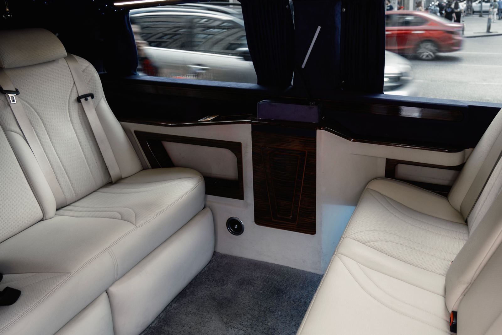 View of city traffic through the tinted window of a limousine interior