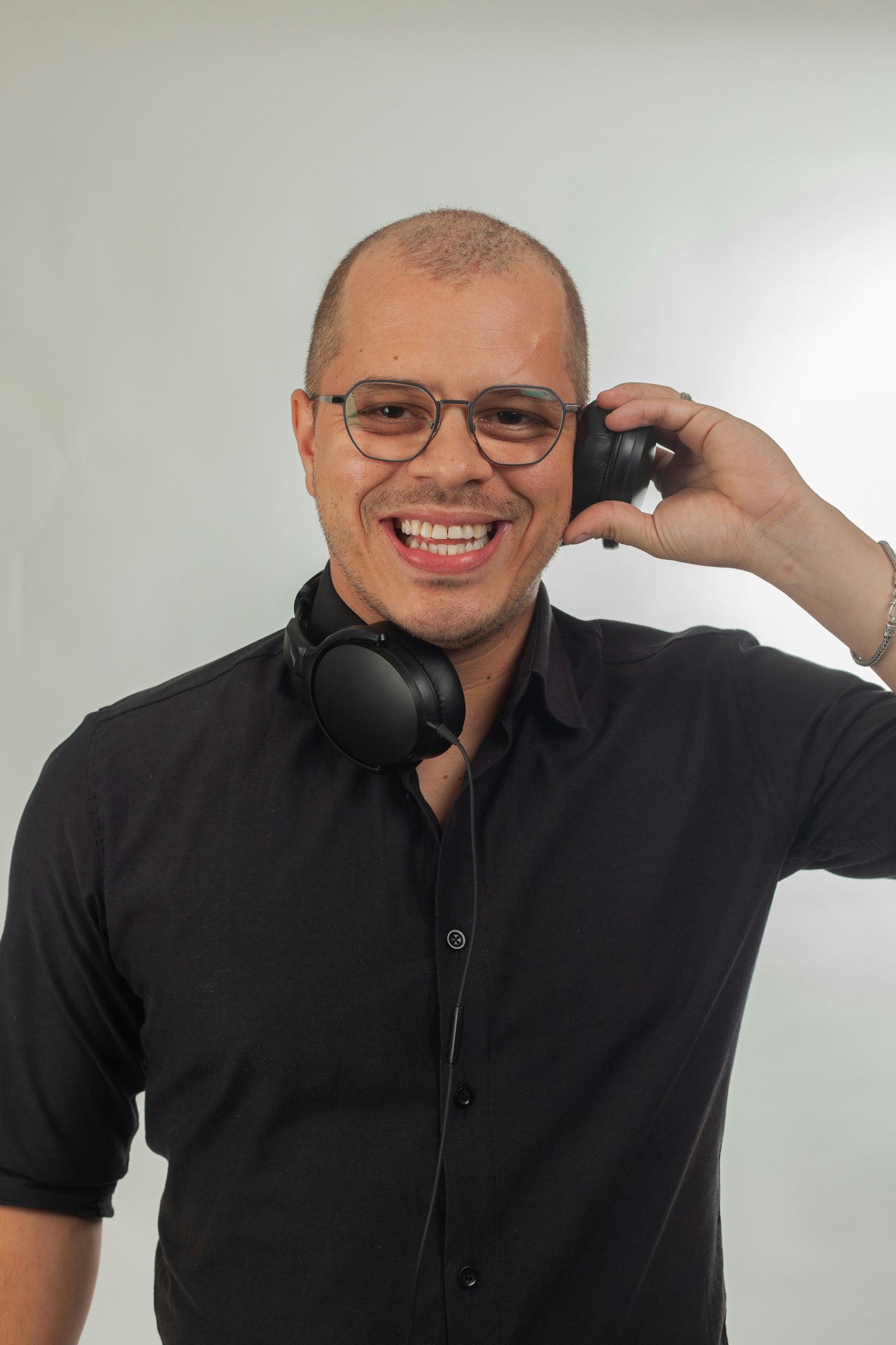 Smiling man wearing headphones against a plain background