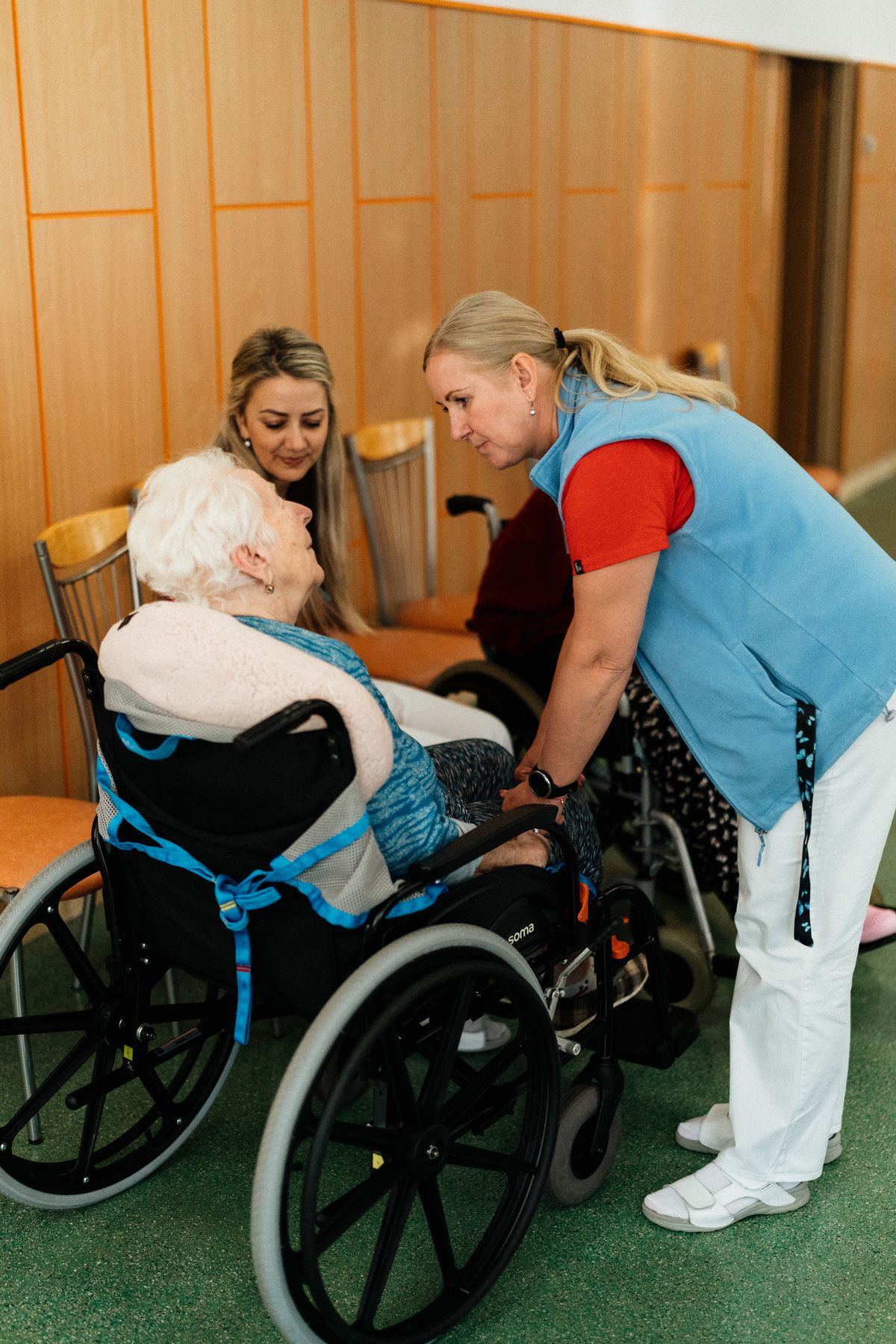 Caregiver speaking with an elderly patient in a wheelchair, illustrating non-emergency medical transport