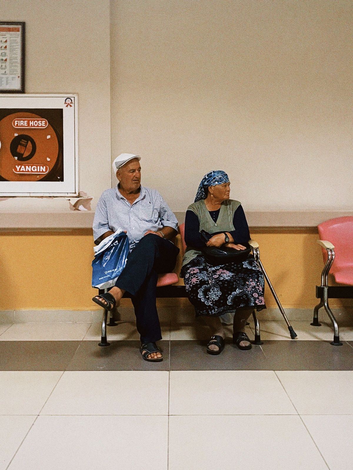 Patients waiting in a hospital corridor seating area