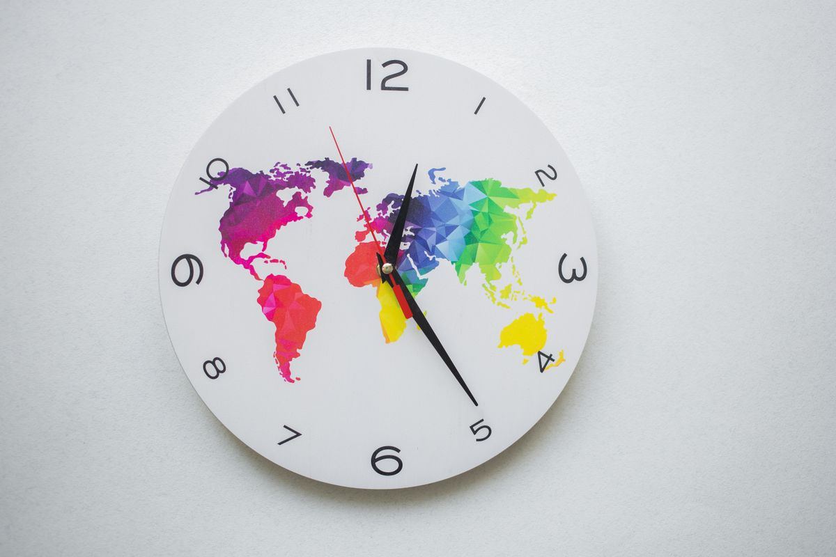 Wall clock with a world map face, representing time-critical dialysis trip scheduling