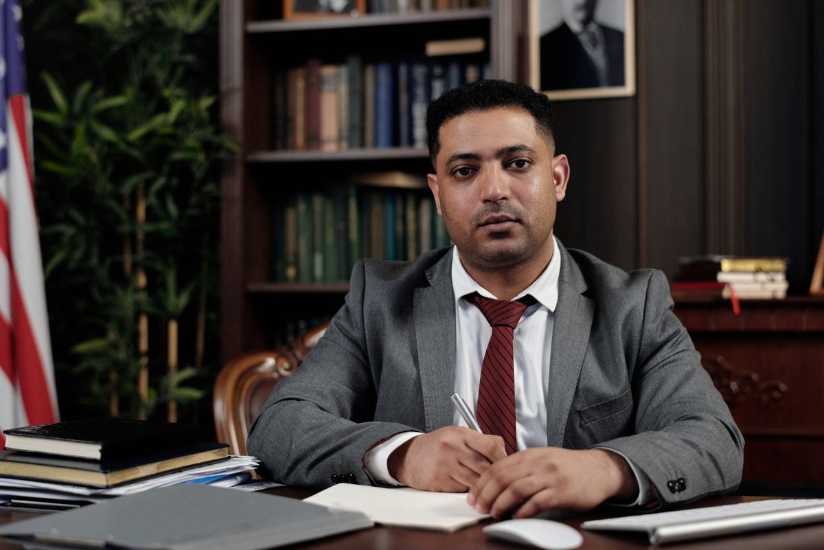Businessman signing a document at a desk, representing Medicaid broker trip offer reconciliation