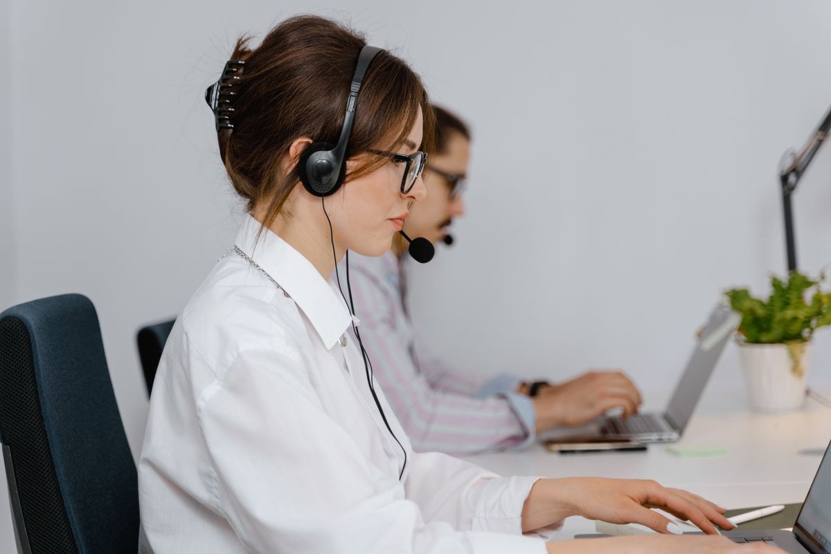 Two call center agents working at their desks with headsets