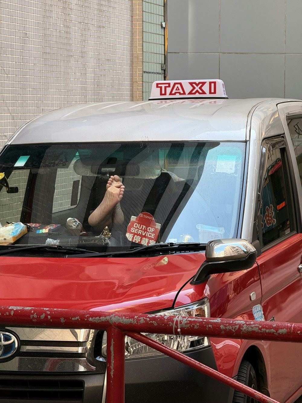 Taxi driver resting with feet propped up on the dashboard during an off-duty break