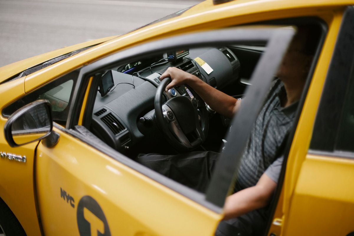 Overhead angle of a taxi driver with hands on the wheel