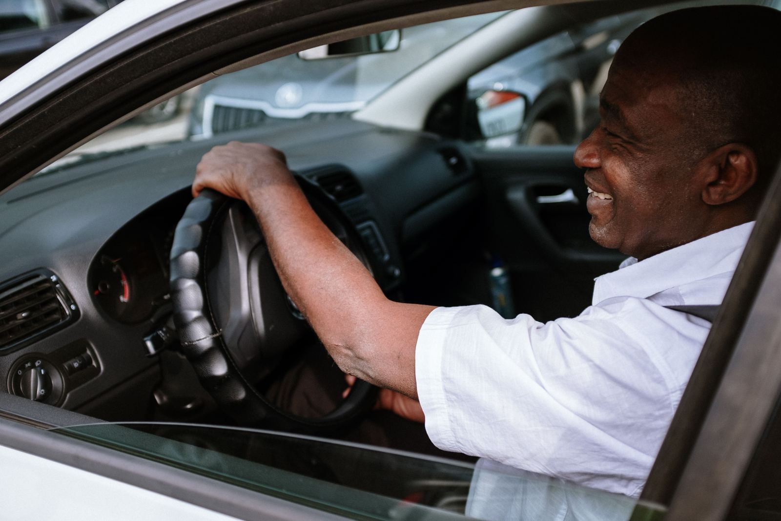 Smiling driver seen in side profile behind the wheel
