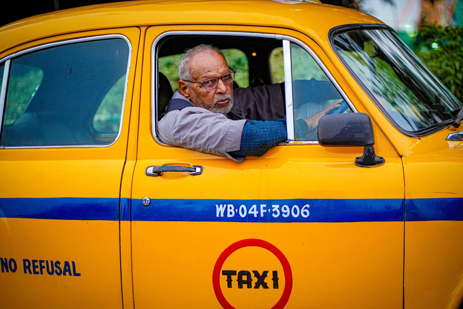 Yellow taxi with a driver looking out the window