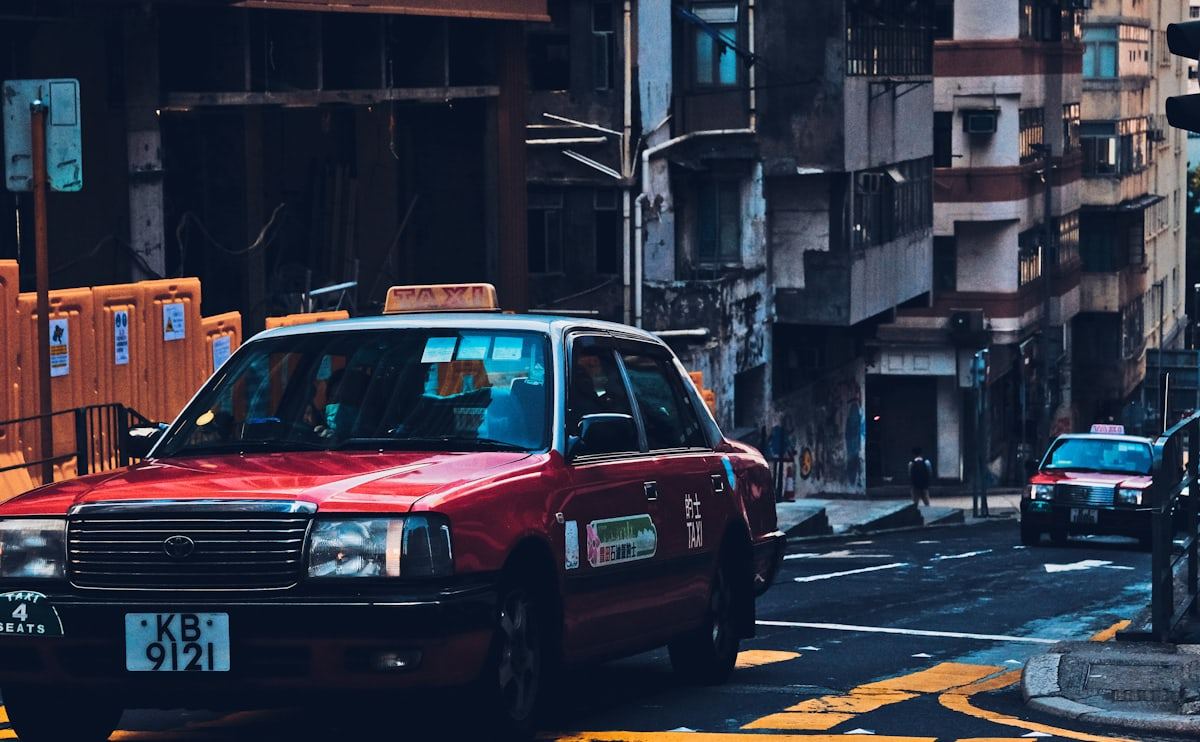 Red taxi cab on a city street at dusk