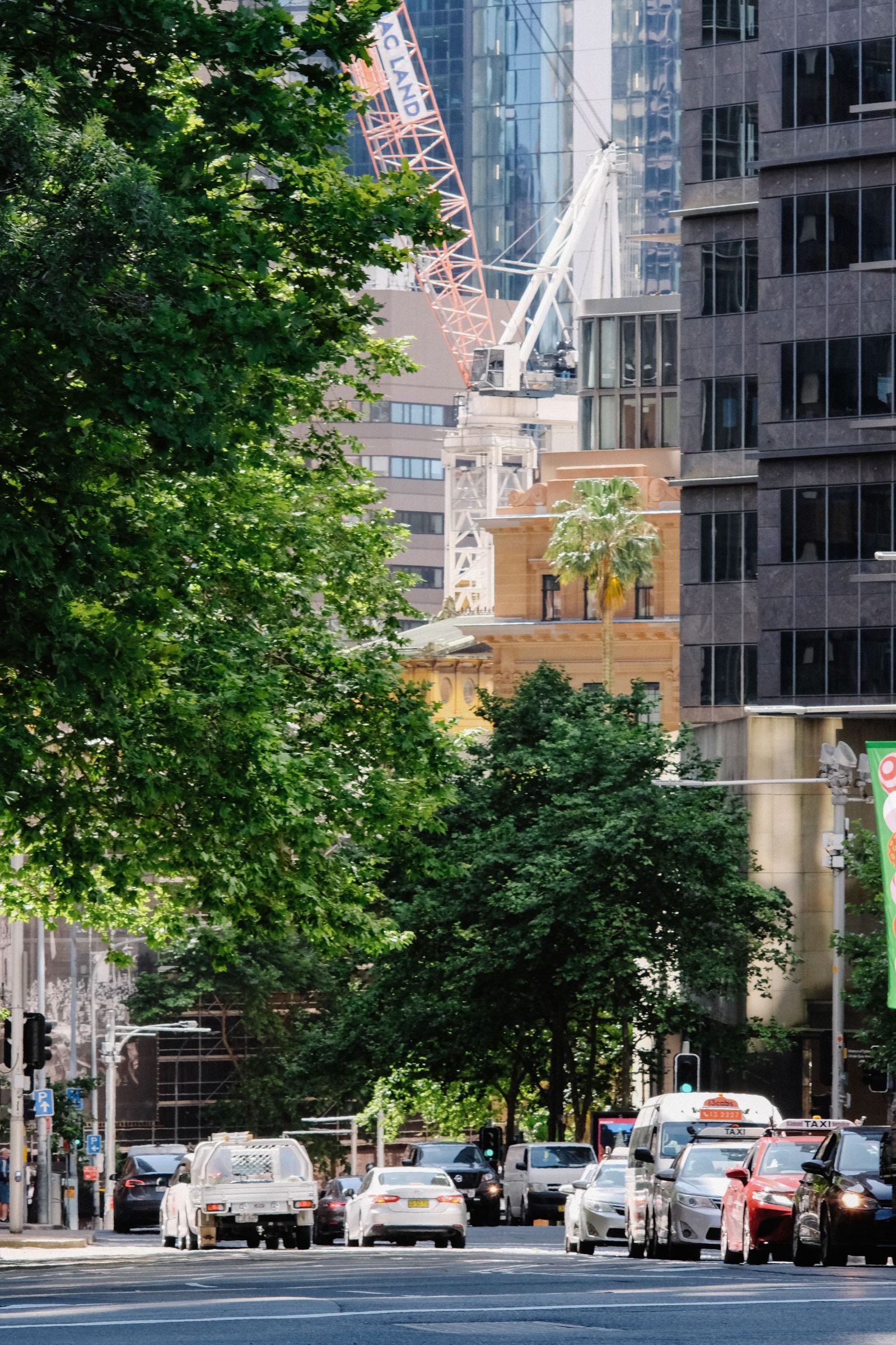 Wide view of a city street with taxis and traffic beneath high-rise buildings