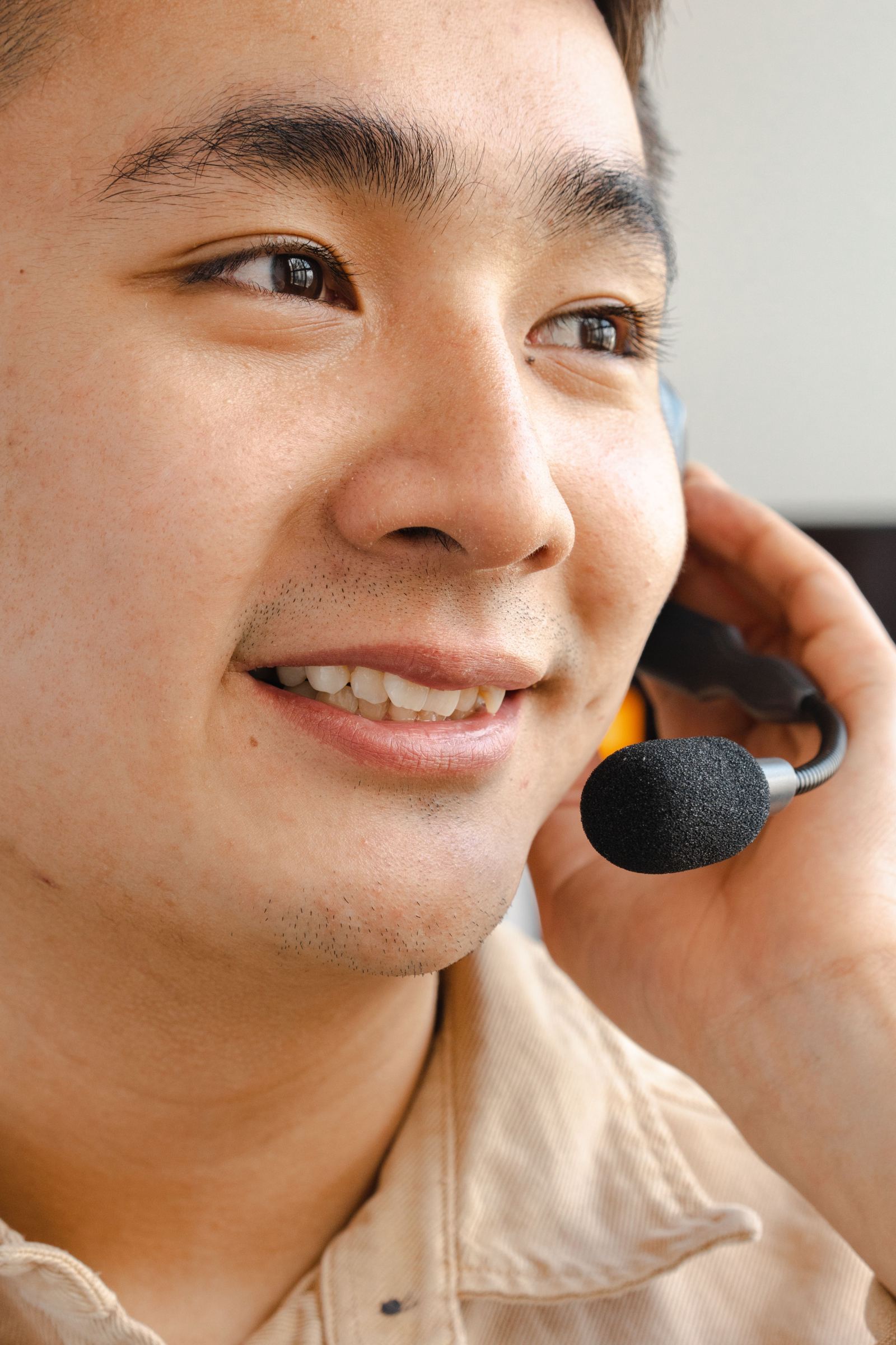 Close-up of a smiling dispatcher speaking through a headset