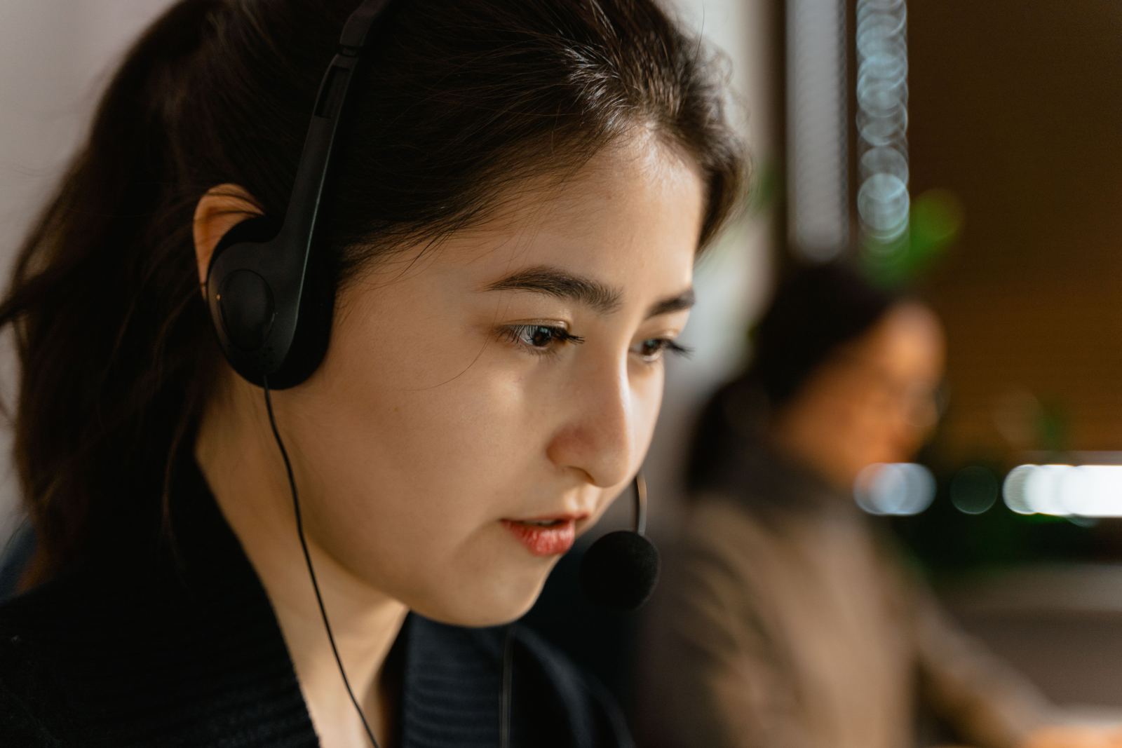 Close-up of a dispatcher wearing a headset in a modern office
