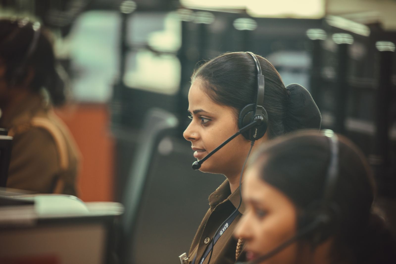 Dispatcher wearing a headset at her desk in a busy office