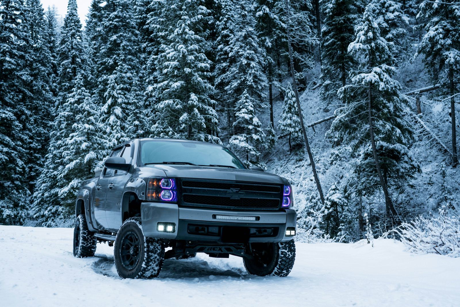 Lifted pickup truck parked in a snow-covered forest