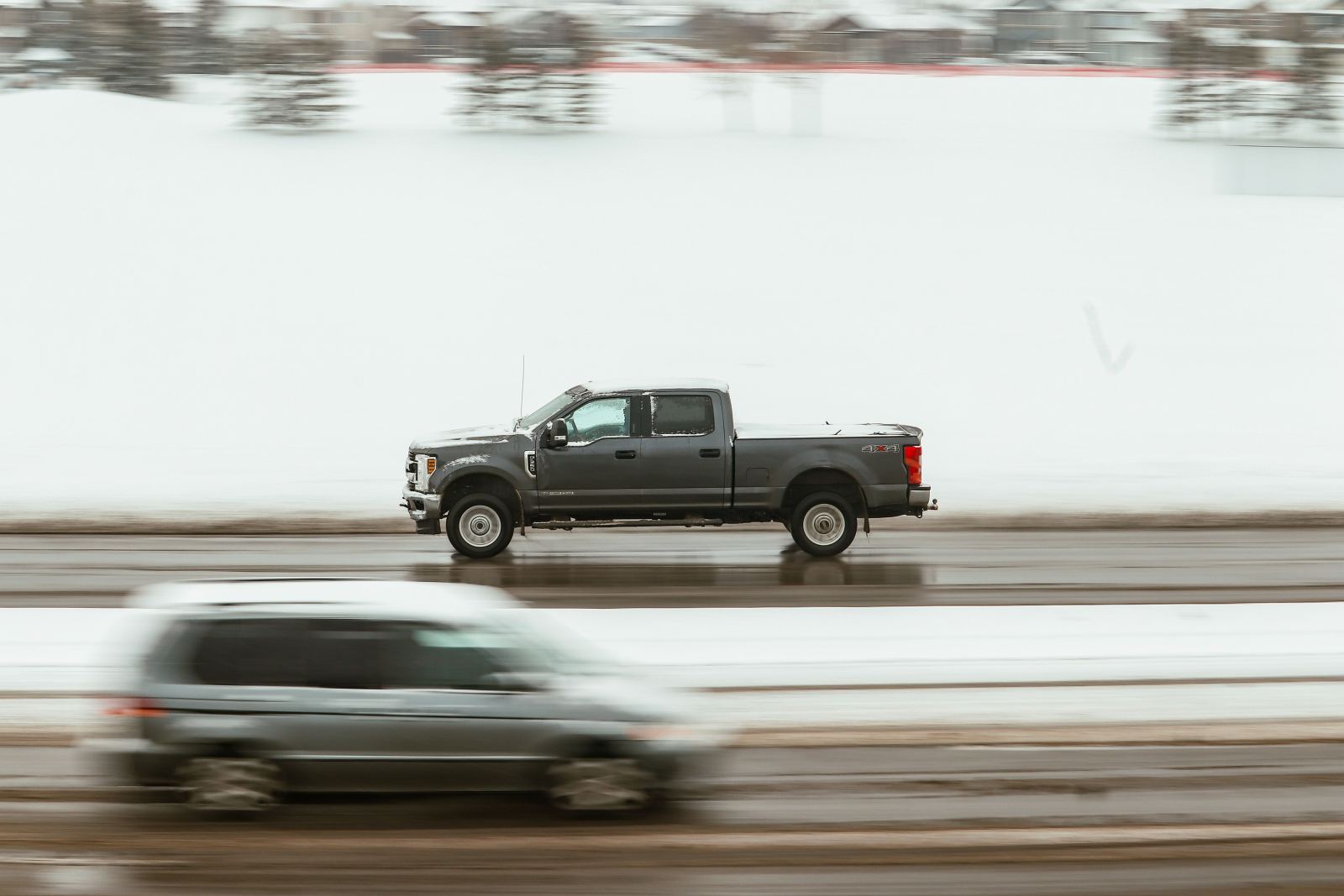 Pickup truck driving along a snow-covered highway