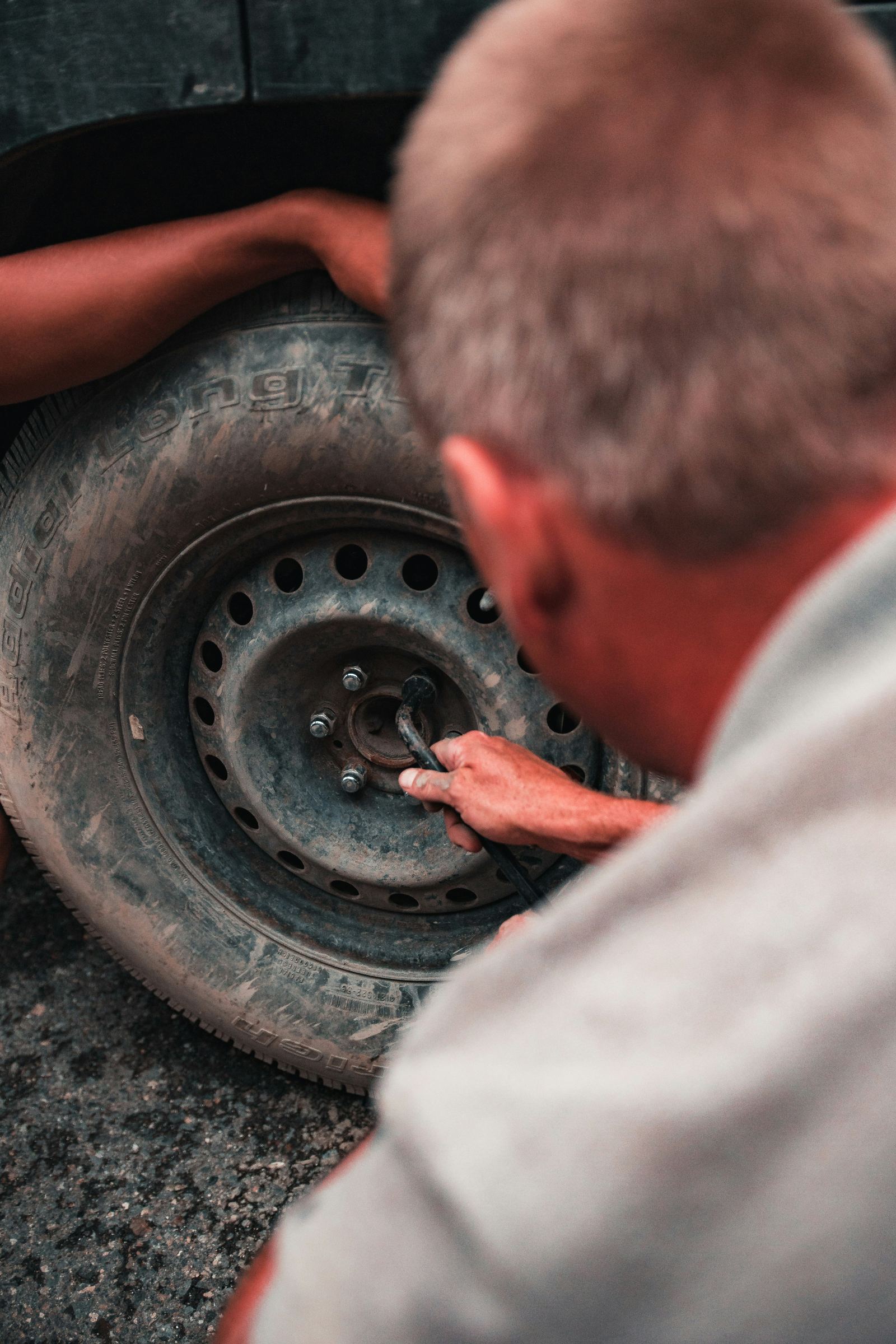 Close-up of a roadside technician changing a flat tire on a vehicle