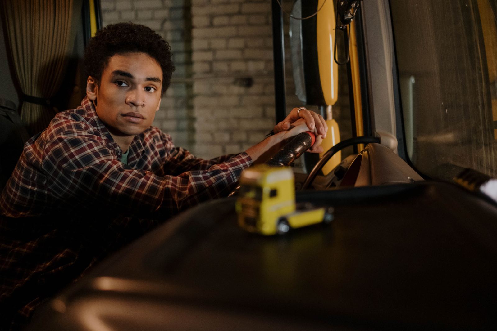 Young truck driver glancing back from inside the cab