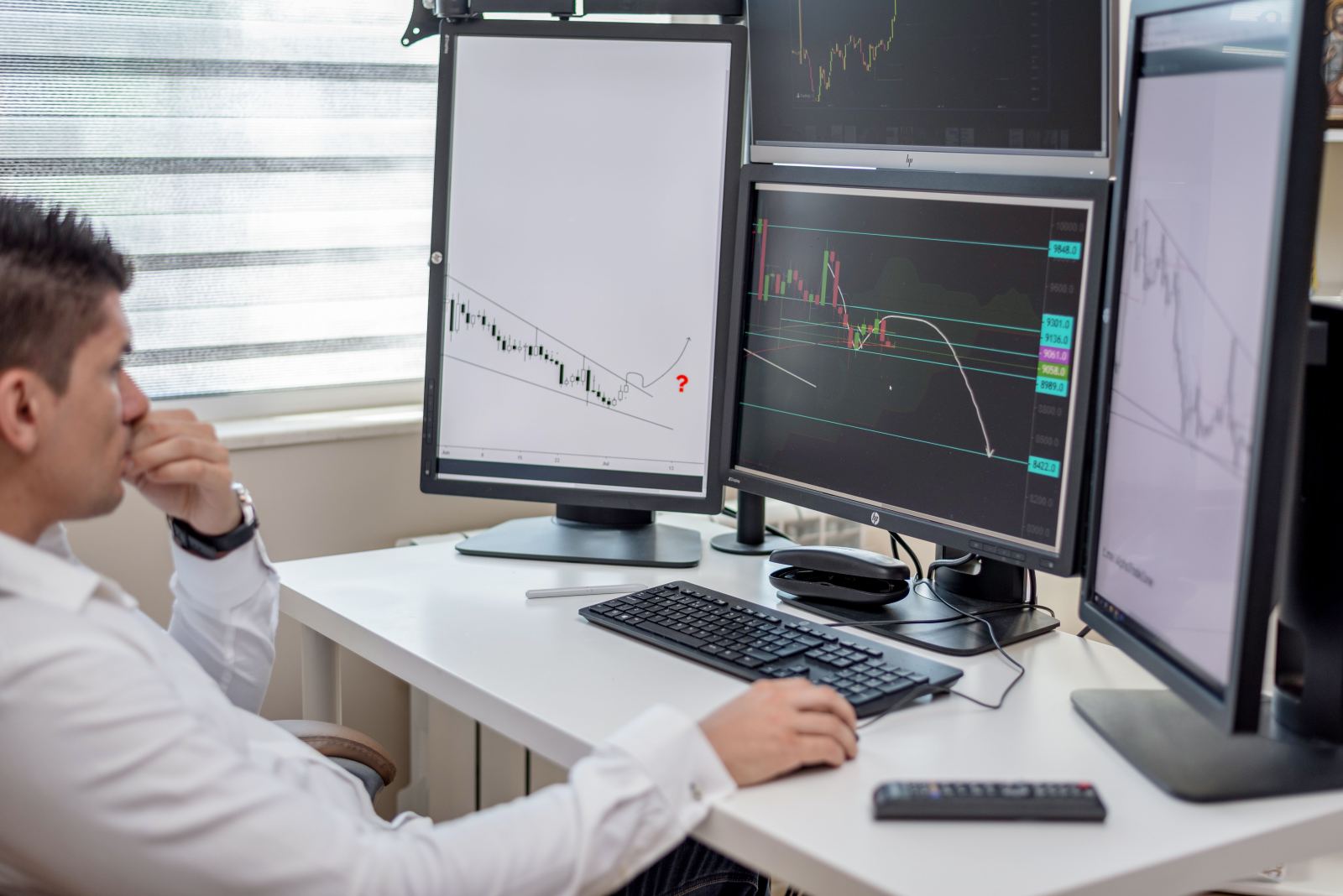 Person reviewing financial charts on multiple monitors, representing dispatch fee structures