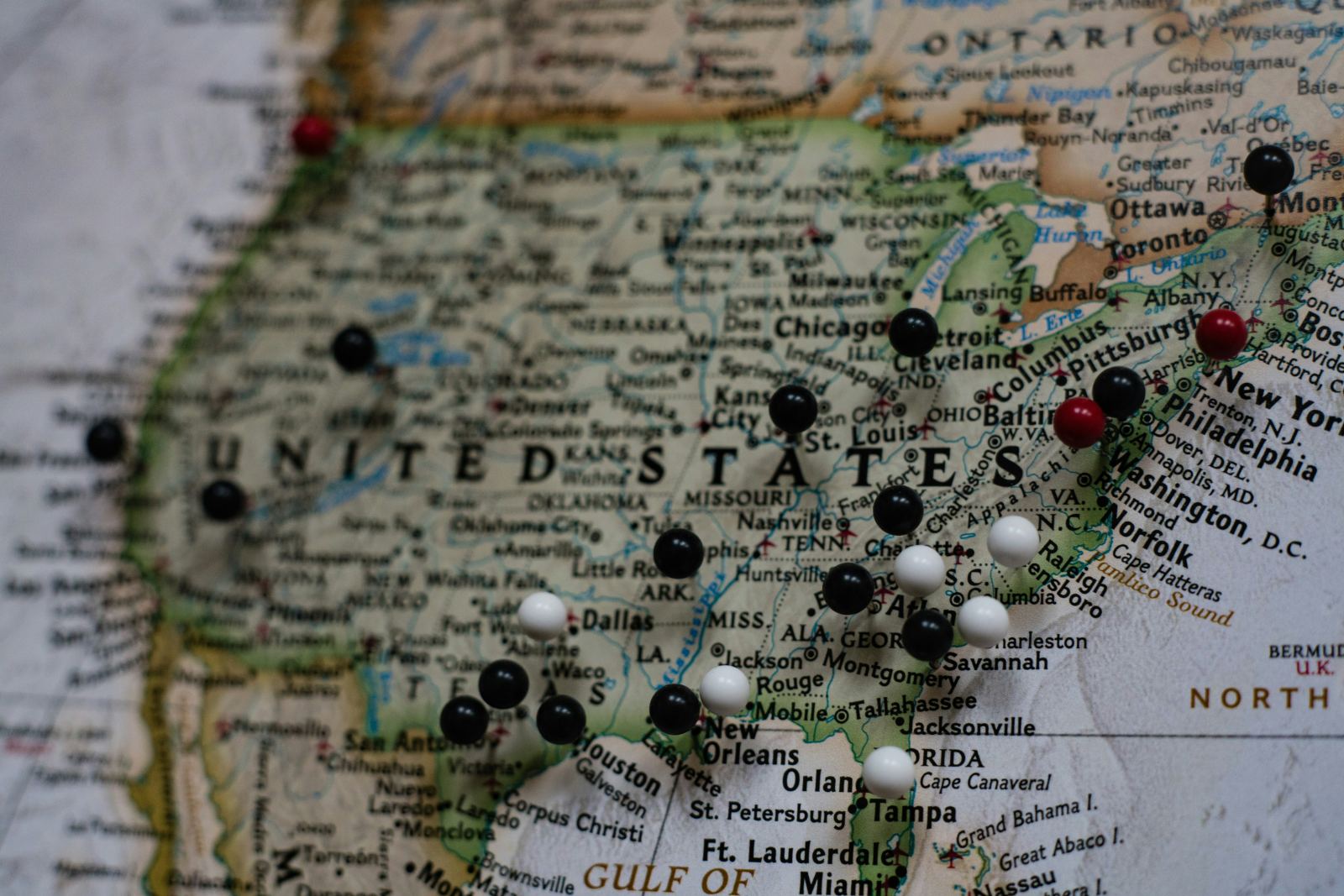 Close-up of a United States map with pushpins marking various cities