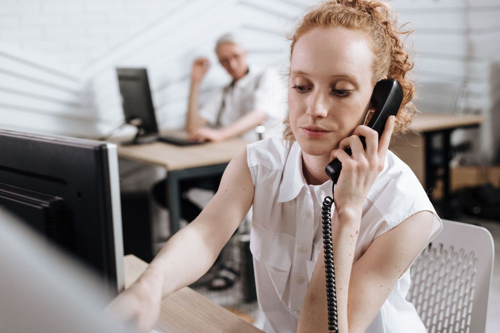 Woman speaking on a corded office phone at her desk