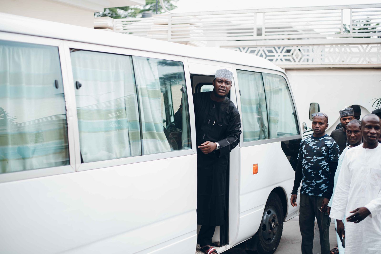 Passengers boarding a white community transport minibus