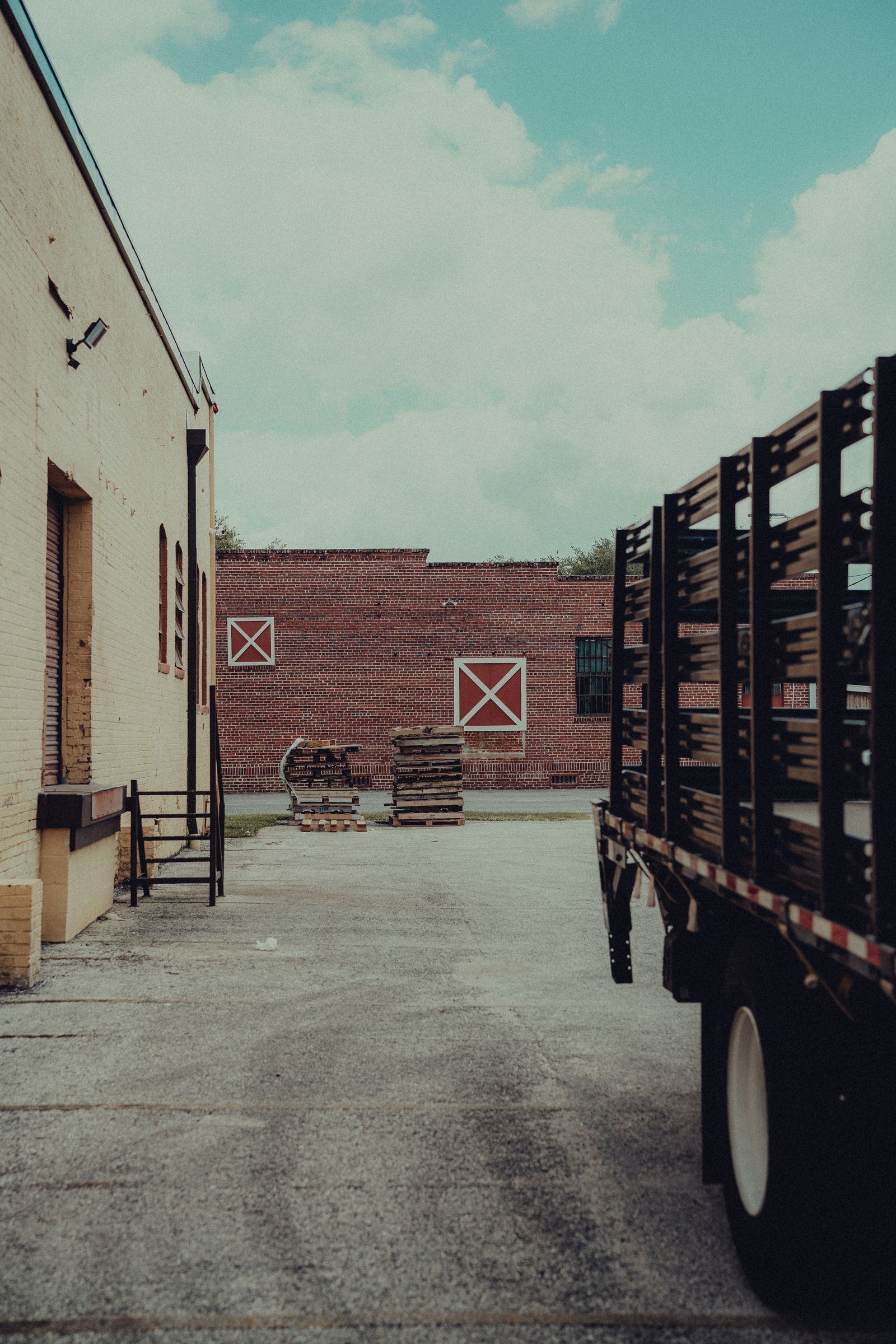 Flatbed truck beside a warehouse loading dock alley