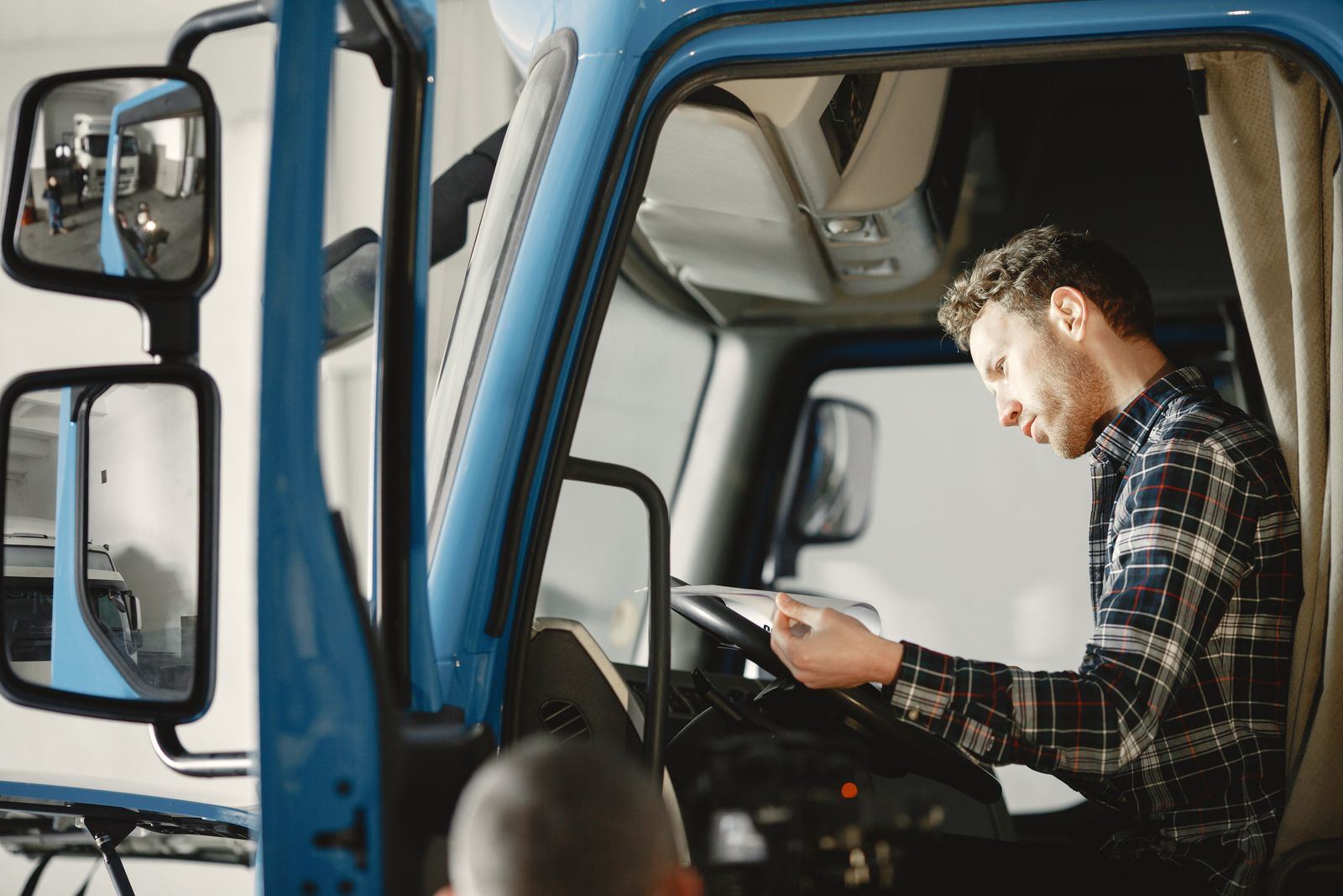 Mechanic reviewing a checklist inside a truck cab