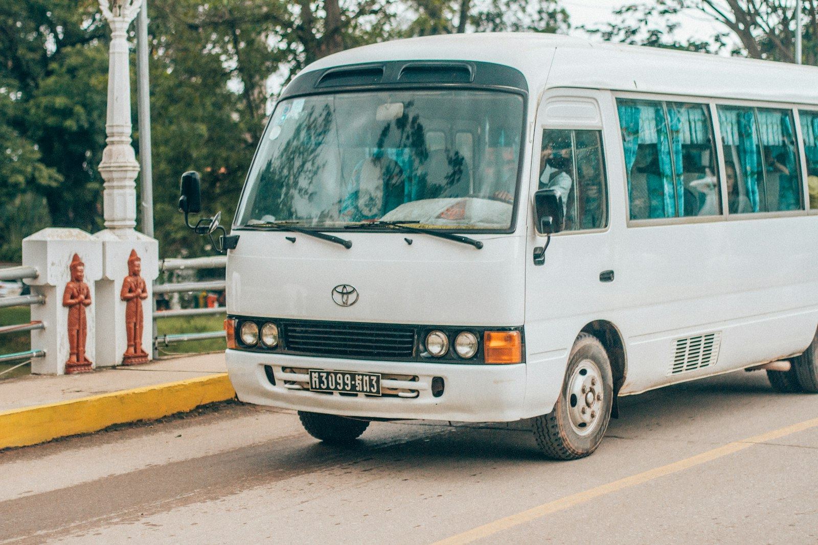 White passenger shuttle minibus with seated riders visible through the windows